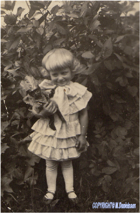 Älva Margareta Almgren,gift Ramstedt, i söt klänning, rosett under hakan  och sin docka, klicka för stor bild ..
